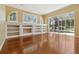 Living room with hardwood flooring, built-in shelving, and large window with pool view at 5240 Silver Charm Ter, Wesley Chapel, FL 33544
