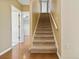 Carpeted stairs lead to the upper level of the home, with glimpses of other rooms at 5240 Silver Charm Ter, Wesley Chapel, FL 33544