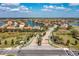 Neighborhood entrance with brick-paved road, lush landscaping, and serene lakes create an inviting community atmosphere at 5511 Foxfire Run, Lakewood Ranch, FL 34211