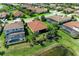 Aerial view of a home highlighting its proximity to a pond, nearby homes, and manicured lawns at 5511 Foxfire Run, Lakewood Ranch, FL 34211