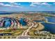 Aerial showcases a lakefront residential community featuring lush green spaces, winding roads, and pristine lakes at 5511 Foxfire Run, Lakewood Ranch, FL 34211