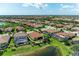 Aerial shot of property showcasing tile roof, backyard, and proximity to a pond and mature landscaping at 5511 Foxfire Run, Lakewood Ranch, FL 34211