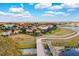 Backyards with manicured lawns lead to a scenic walking path by the lake, with mature trees and landscaping at 5511 Foxfire Run, Lakewood Ranch, FL 34211