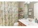 Charming bathroom showcasing a floral shower curtain, vanity, and decorative shelves at 5511 Foxfire Run, Lakewood Ranch, FL 34211