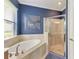 Clean and bright bathroom featuring a soaking tub, glass shower, and stylish decor at 5511 Foxfire Run, Lakewood Ranch, FL 34211