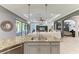 Gourmet kitchen featuring an island with a sink, stainless appliances, and an open layout to the living area at 5511 Foxfire Run, Lakewood Ranch, FL 34211