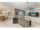 Open kitchen features a granite island with a sink, stainless appliances, and seamless flow to the dining and living spaces at 5511 Foxfire Run, Lakewood Ranch, FL 34211