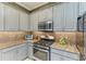Well-equipped kitchen features stainless steel appliances, granite counters, and modern finishes at 5511 Foxfire Run, Lakewood Ranch, FL 34211