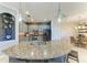 Open kitchen boasts an island with seating, modern appliances, and a seamless flow into the dining area at 5511 Foxfire Run, Lakewood Ranch, FL 34211