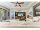 Relaxing living room featuring neutral tones, a ceiling fan, and an entertainment center with coastal decor at 5511 Foxfire Run, Lakewood Ranch, FL 34211
