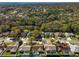 An aerial view showing a quiet neighborhood of residences, some with screened-in pools and mature trees at 5565 Sweetwater Oak Dr, Sarasota, FL 34232