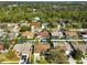 An aerial view of a neighborhood showcasing various homes, some featuring screened-in pools and lush landscaping at 5565 Sweetwater Oak Dr, Sarasota, FL 34232