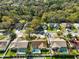 Aerial view of homes with backyard pools in a neighborhood surrounded by lush trees and a pond at 5565 Sweetwater Oak Dr, Sarasota, FL 34232