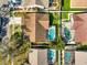 An aerial view showcases the home's location and the sparkling pool within a screened enclosure at 5565 Sweetwater Oak Dr, Sarasota, FL 34232