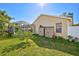 The backyard features a well-maintained lawn, mature landscaping, storage, and a screened-in pool area at 5565 Sweetwater Oak Dr, Sarasota, FL 34232