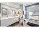 Elegant bathroom with a soaking tub, modern fixtures, and lots of counter space at 5565 Sweetwater Oak Dr, Sarasota, FL 34232
