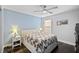 Cozy bedroom with a ceiling fan, hardwood floors, and a white bedside table at 5565 Sweetwater Oak Dr, Sarasota, FL 34232