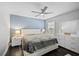 Bright bedroom features a queen-size bed, a ceiling fan, and white furniture at 5565 Sweetwater Oak Dr, Sarasota, FL 34232