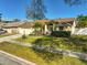 Lovely home featuring a manicured lawn, a palm tree, and a convenient two-car garage at 5565 Sweetwater Oak Dr, Sarasota, FL 34232