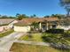 Charming one-story home with a well-manicured lawn, mature landscaping, and a two car garage at 5565 Sweetwater Oak Dr, Sarasota, FL 34232