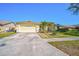 Lovely single-story home featuring a manicured lawn, stone walkway, and attached two-car garage at 5565 Sweetwater Oak Dr, Sarasota, FL 34232