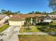 Inviting single-story home with a lush green lawn, palm tree, and a convenient two-car garage at 5565 Sweetwater Oak Dr, Sarasota, FL 34232