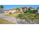 Beautiful single-story home with lush front lawn, mature landscaping, and a charming entrance with a decorative front door at 5565 Sweetwater Oak Dr, Sarasota, FL 34232