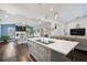 Open concept kitchen with hardwood floors, center island with a cooktop, pendant lighting, and views of the living area at 5565 Sweetwater Oak Dr, Sarasota, FL 34232