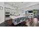 Bright, open-concept kitchen featuring a large center island with seating, modern cabinetry, and hardwood floors at 5565 Sweetwater Oak Dr, Sarasota, FL 34232
