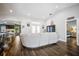 Open concept living room with hardwood floors, white sofa, views of dining room, kitchen, and primary bedroom at 5565 Sweetwater Oak Dr, Sarasota, FL 34232