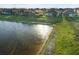 Community pond bordered by the grassy backyards of single Gathering homes featuring screened in patios at 6239 Baywood Ct, Bradenton, FL 34211
