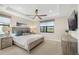 Bright bedroom featuring a ceiling fan, large windows, and stylish wooden furniture at 6239 Baywood Ct, Bradenton, FL 34211