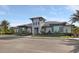 Beautiful clubhouse featuring modern architecture, blue accents, manicured landscaping, and ample parking on a sunny day at 6239 Baywood Ct, Bradenton, FL 34211