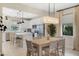 Elegant dining area with a large table, stylish chairs, modern lighting, and an open view to the kitchen at 6239 Baywood Ct, Bradenton, FL 34211