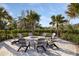 Inviting outdoor fire pit area with comfortable seating, surrounded by lush greenery and palm trees for cozy gatherings at 6239 Baywood Ct, Bradenton, FL 34211