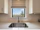 Close-up of a kitchen sink with a view of the backyard, showing the quartz countertops and tile backsplash at 6239 Baywood Ct, Bradenton, FL 34211