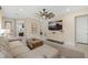 Open-concept living room with a neutral color palette, sleek entertainment center, and seamless flow to other areas of the home at 6239 Baywood Ct, Bradenton, FL 34211