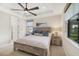 Bright main bedroom with tray ceiling, ceiling fan, and bedside lamps at 6239 Baywood Ct, Bradenton, FL 34211