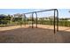 Community swings with soft mulch surface and nearby lush foliage for recreation at 6239 Baywood Ct, Bradenton, FL 34211