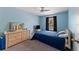 Cozy bedroom features soothing blue walls, ceiling fan, and ample natural light from the window at 712 68Th W Ave, Bradenton, FL 34207