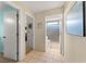 Hallway features neutral paint, tile floors, and access to other rooms, including a full bathroom at 712 68Th W Ave, Bradenton, FL 34207
