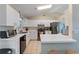 Well-lit kitchen features white cabinets, stainless steel appliances, and tile flooring at 712 68Th W Ave, Bradenton, FL 34207