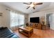 Bright living room featuring a TV, wood floors, ceiling fan, and large window with natural light at 712 68Th W Ave, Bradenton, FL 34207