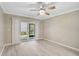 Empty bedroom featuring a ceiling fan, light-colored walls, plank floors, and sliding glass doors to a balcony at 7211 Cloister Dr # 101, Sarasota, FL 34231