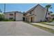 Neutral toned condominium building with covered entry and lush landscaping at 7211 Cloister Dr # 101, Sarasota, FL 34231