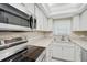 Modern kitchen featuring stainless steel appliances and white cabinetry at 7211 Cloister Dr # 101, Sarasota, FL 34231