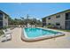 Outdoor pool surrounded by chairs with condos in the background at 7211 Cloister Dr # 101, Sarasota, FL 34231