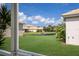 Backyard with manicured lawn and a tranquil pond, offering serene views at 7432 Birds Eye Ter, Bradenton, FL 34203
