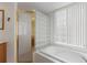 Bathroom with soaking tub, glass block partition, and shower with gold door at 7432 Birds Eye Ter, Bradenton, FL 34203