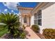 Inviting front entrance with brick walkway, arched windows, and lush landscaping, offering a warm welcome at 7432 Birds Eye Ter, Bradenton, FL 34203